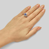 Unique round cut sapphire engagement ring with surrounding diamonds