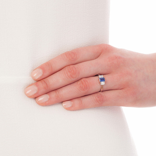 Emerald cut sapphire engagement ring on model