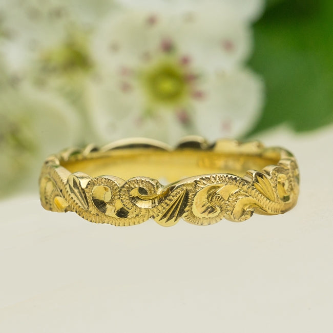 Patterned yellow gold wedding ring on paper