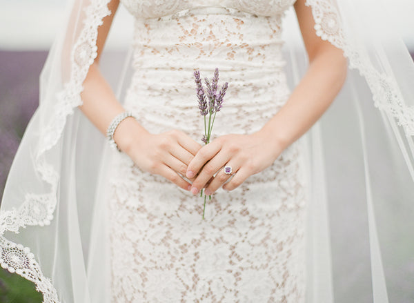 Bride wearing amethyst cluster ring and holding purple lavender