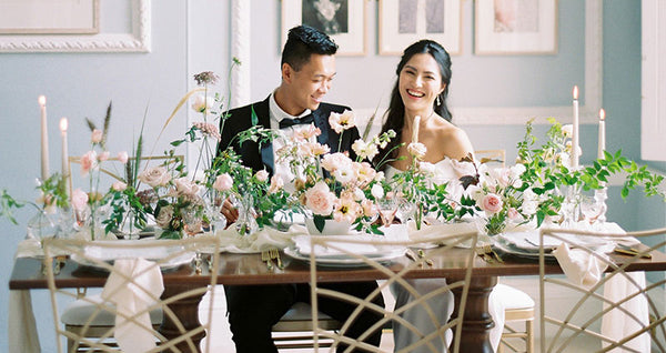 Bride and groom at ornate table with flowers and candles