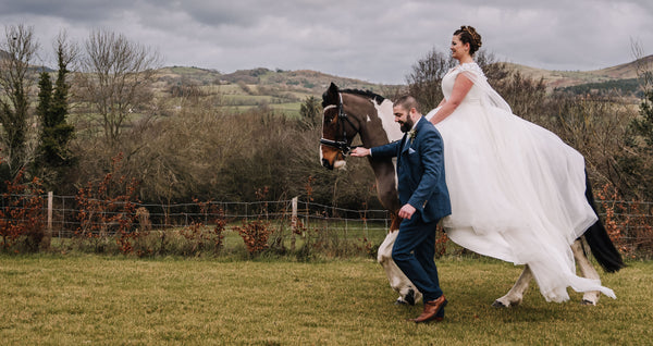 Bride riding a horse with groom walking alongside
