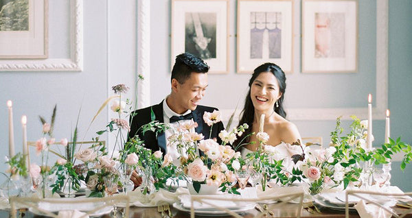Bride and groom at wedding table with floral bouquets
