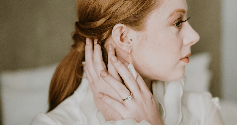 Solitaire round diamond engagement ring on the finger of bride