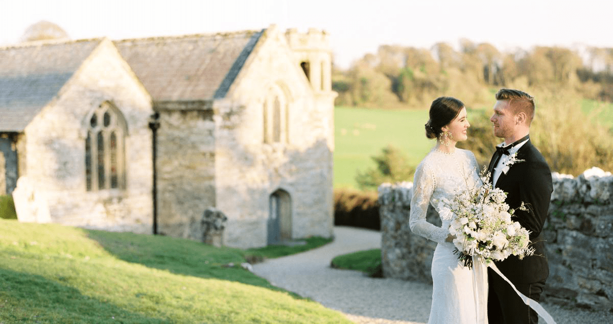 Bride and groom outside church in countryside wedding