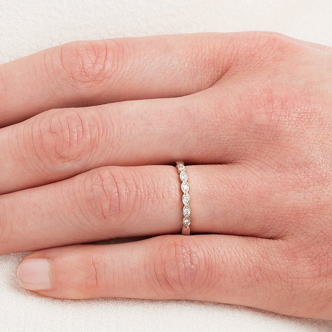 Scalloped vintage diamond wedding band on model hand