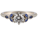 Diamond ring with blue sapphire gemstones on a white background