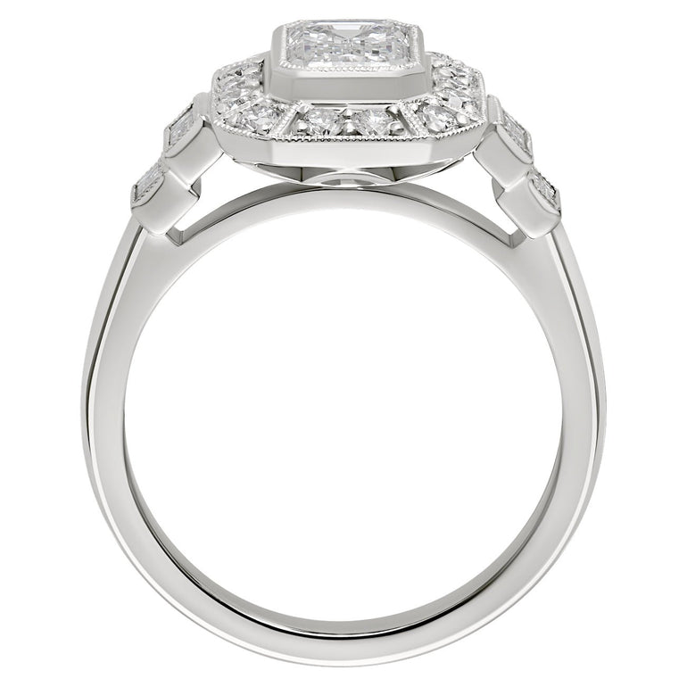 Vintage inspired emerald cut diamond halo ring with baguette diamond accents in platinum. Made in Hatton Garden