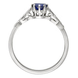 round blue sapphire center stone with scalloped diamond-set shoulders engagement ring in platinum. Made in the UK.