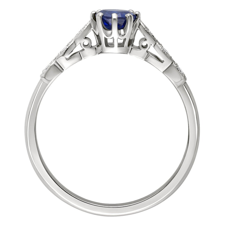 round blue sapphire center stone with scalloped diamond-set shoulders engagement ring in platinum. Made in the UK.