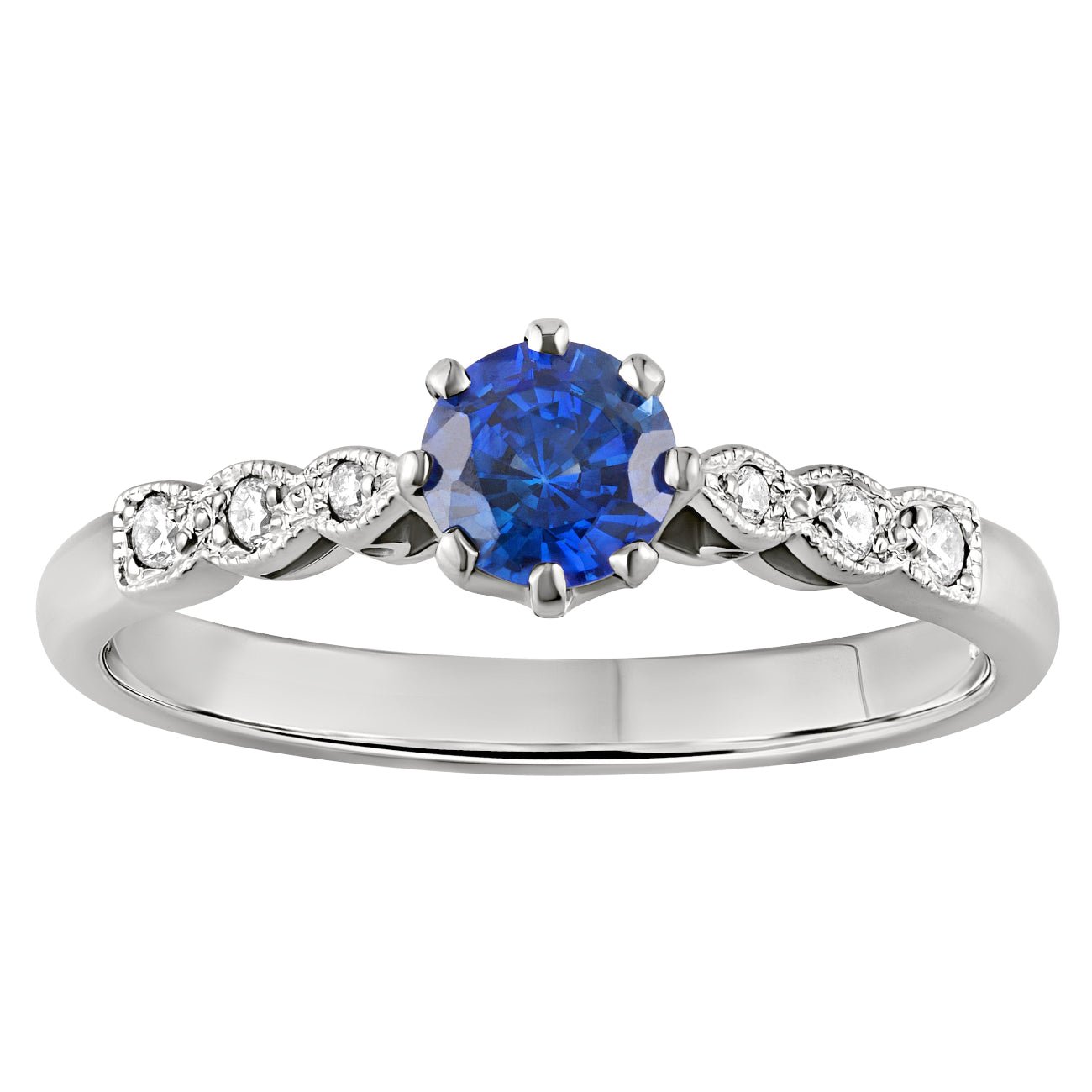 Vintage-inspired blue sapphire engagement ring with diamond accents along a platinum band. Made in London.