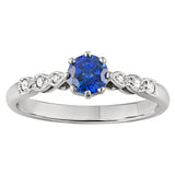 Vintage-inspired blue sapphire engagement ring with diamond accents along a platinum band. Made in London.