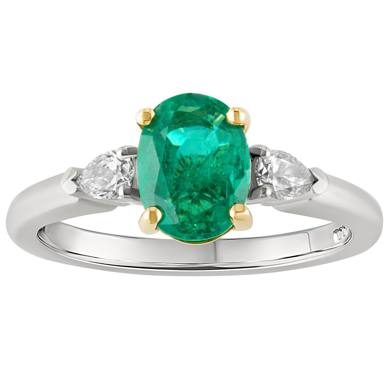 Oval emerald engagement ring set in in platinum with yellow gold claws and pear-shaped diamond side stones. Made in London