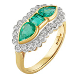 Three-stone emerald and diamond cluster ring featuring a central emerald with pear-cut emeralds on each side, surrounded by a halo of round brilliant diamonds in a yellow gold and white gold setting. Made in London