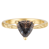 Gold ring with a trillion-cut sapphire diamond on a white background