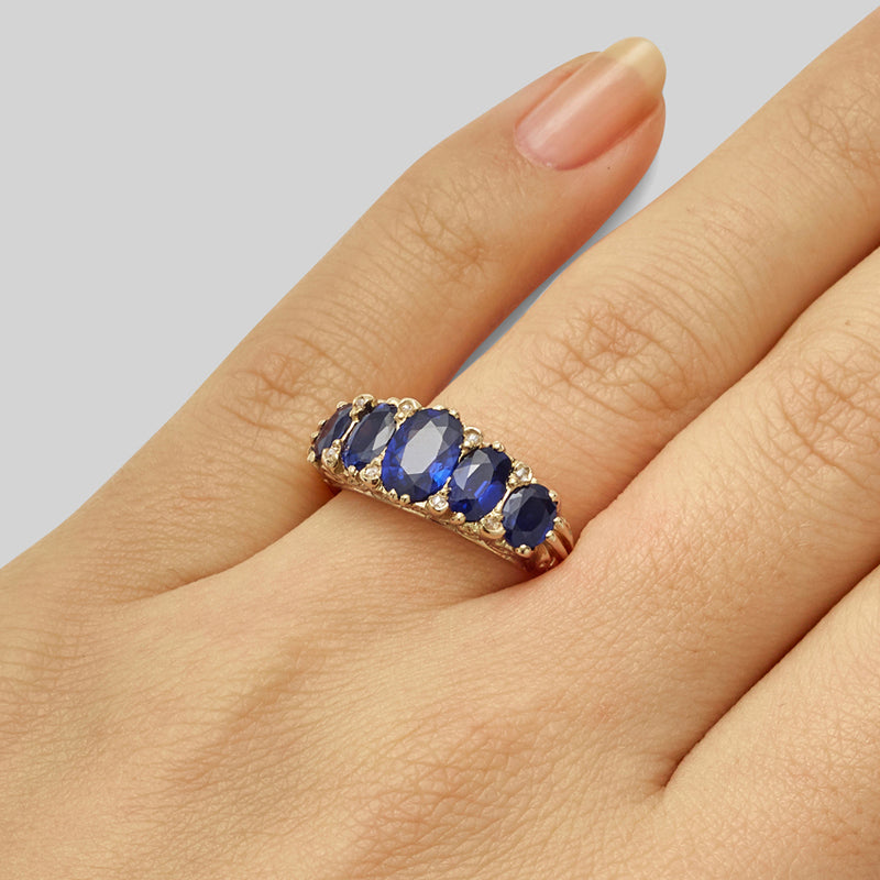 Five stone oval cut sapphire and diamond ring in yellow gold