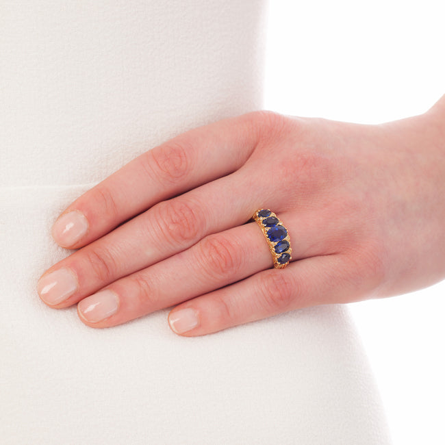 Carved half hoop ring with five sapphires in 18ct yellow gold