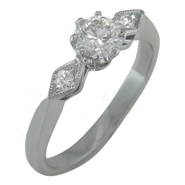 White gold vintage style engagement ring for a round brilliant cut diamond.