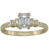 Emerald cut diamond and gold engagement ring in Art Deco style.