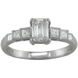 Emerald cut engagement ring with stepped diamond shoulders.