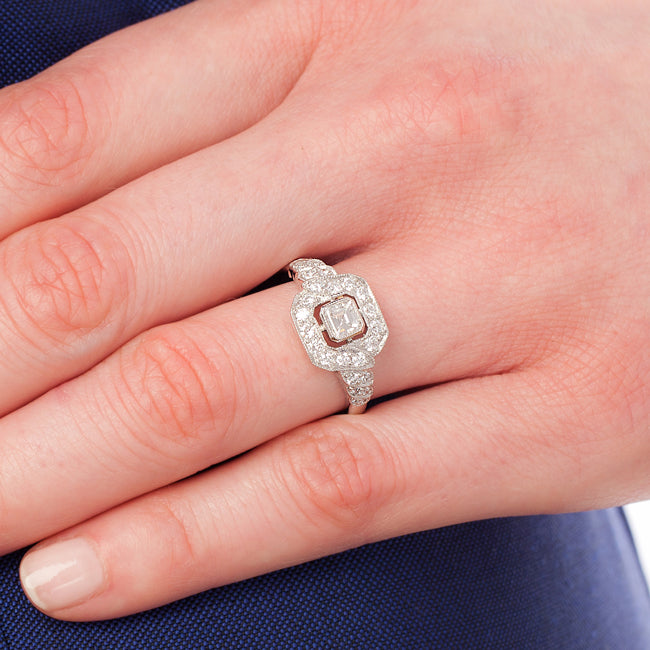 Asscher cut engagement ring on hand.