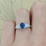 Cushion cut sapphire ring with baguette diamonds in platinum on hand
