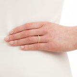 Shaped pave-set diamond wedding ring in yellow gold on hand