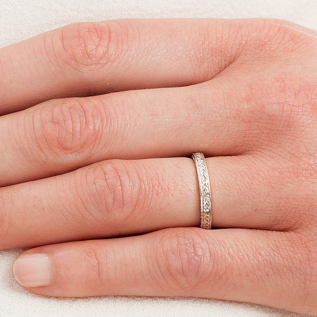 Hand engraved laurel pattern white gold wedding ring