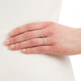 Woman wearing curved diamond wedding band in platinum