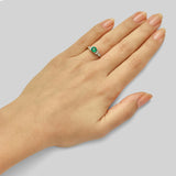 Round emerald engagement ring with floral diamond accents
