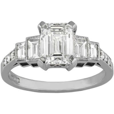 Emerald cut platinum engagement ring with diamond accent band