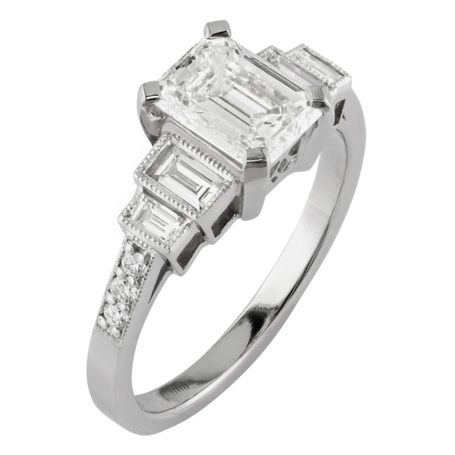 Platinum emerald cut diamond ring with baguette shoulders and diamond band