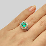 Green emerald halo engagement ring in the Art Deco style