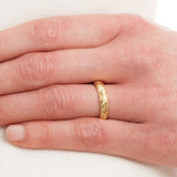 Paisley engraved gold wedding band on hand