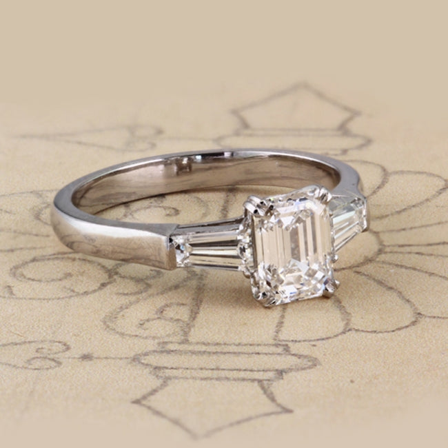 Emerald cut ring with tapered baguettes sides on paper