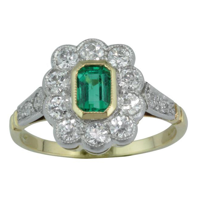 Emerald and diamond cluster ring in elegant Edwardian design.