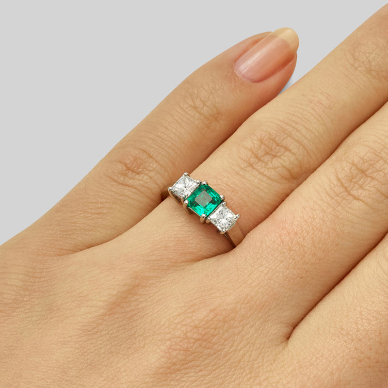 Emerald trilogy engagement ring with diamond side stones