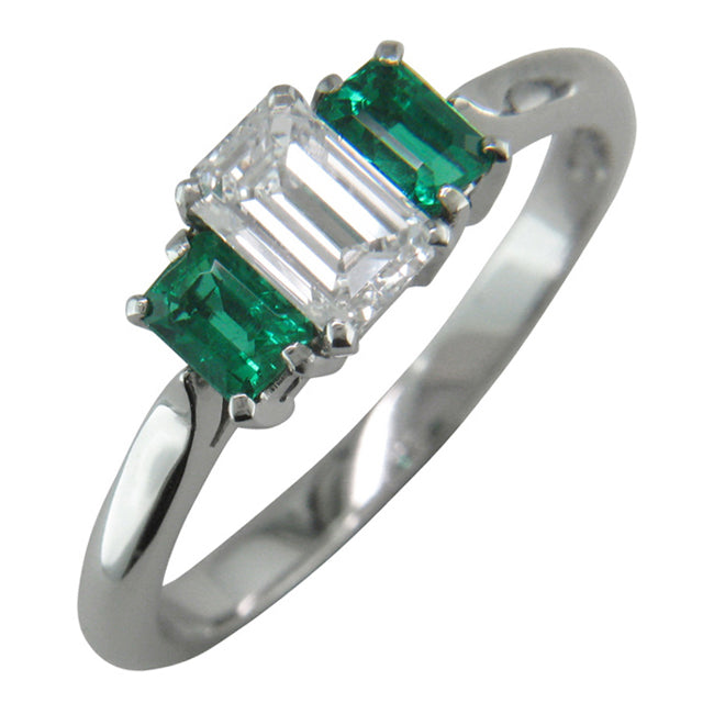 Emerald cut diamond trilogy ring with emerald side stones