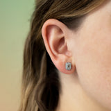 Emerald cut diamond earrings on ear
