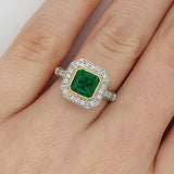 Emerald engagement ring in two tone platinum and yellow gold on hand