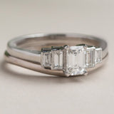 Platinum curved wedding ring with emerald cut diamond ring