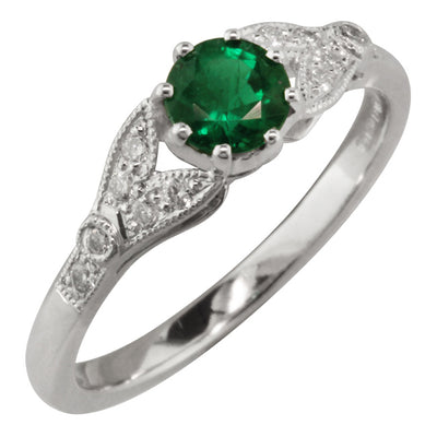Vintage round emerald engagement ring with decorated diamond shoulders 